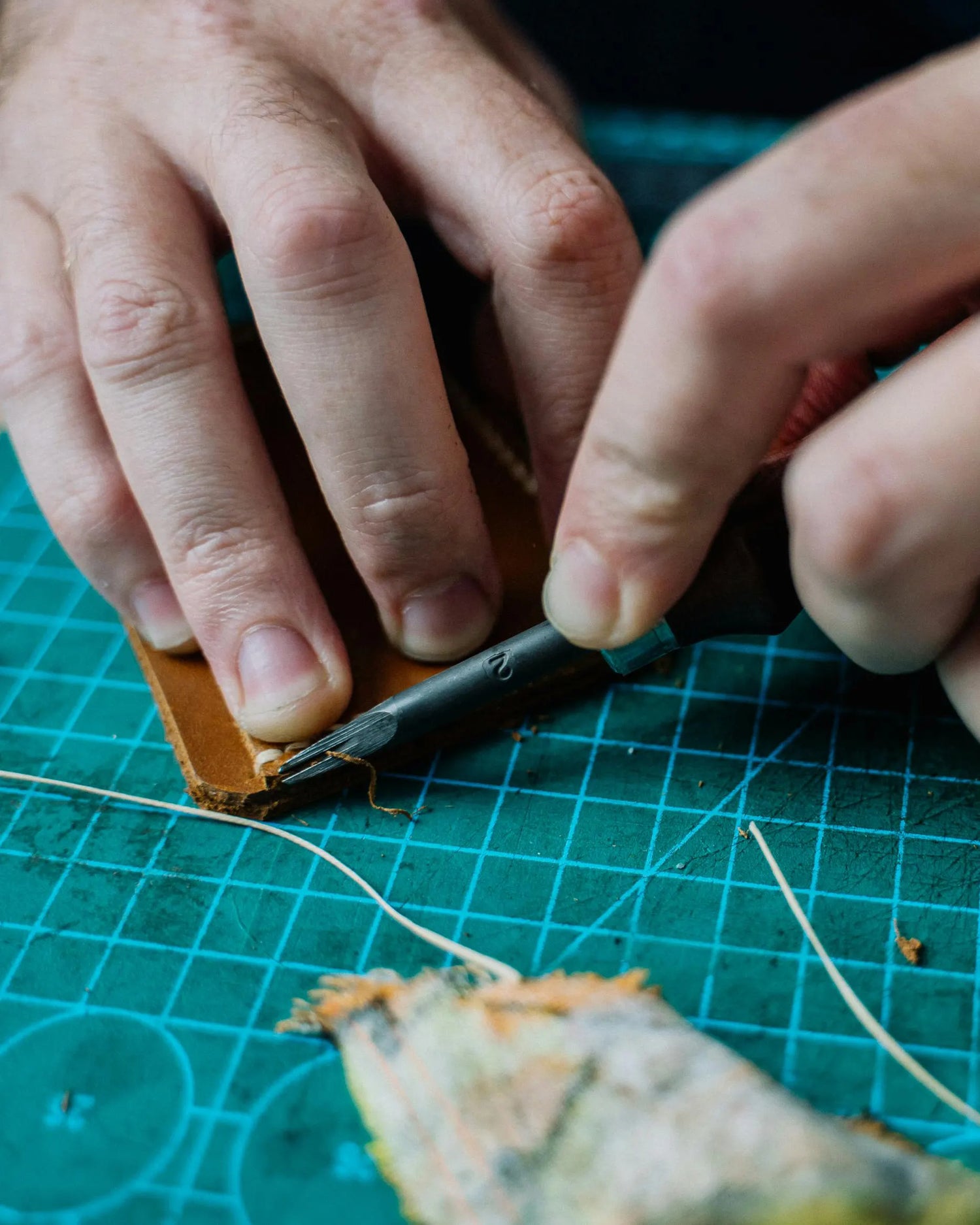 Artisan cutting a piece of leather